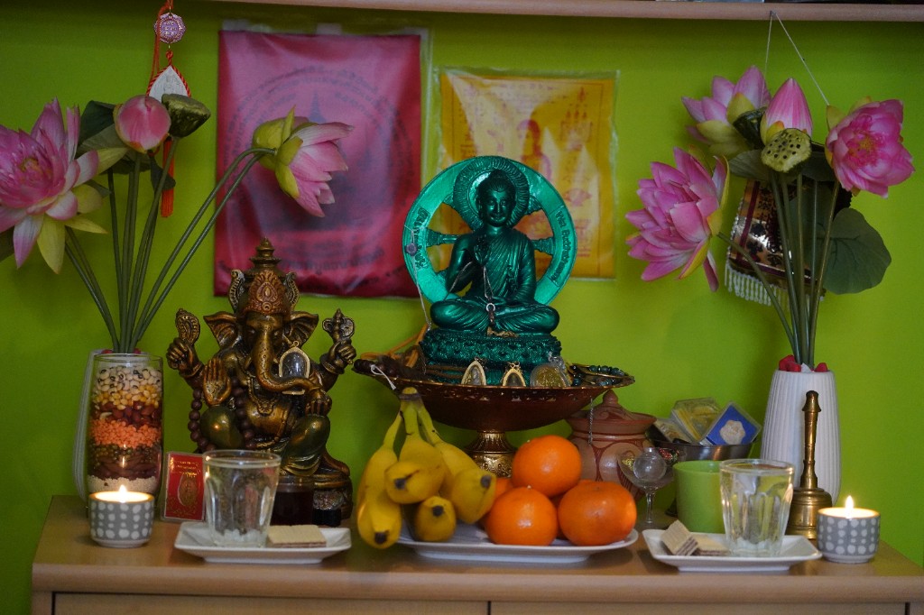 Schrein mit Buddha, Blumen und Opfergaben